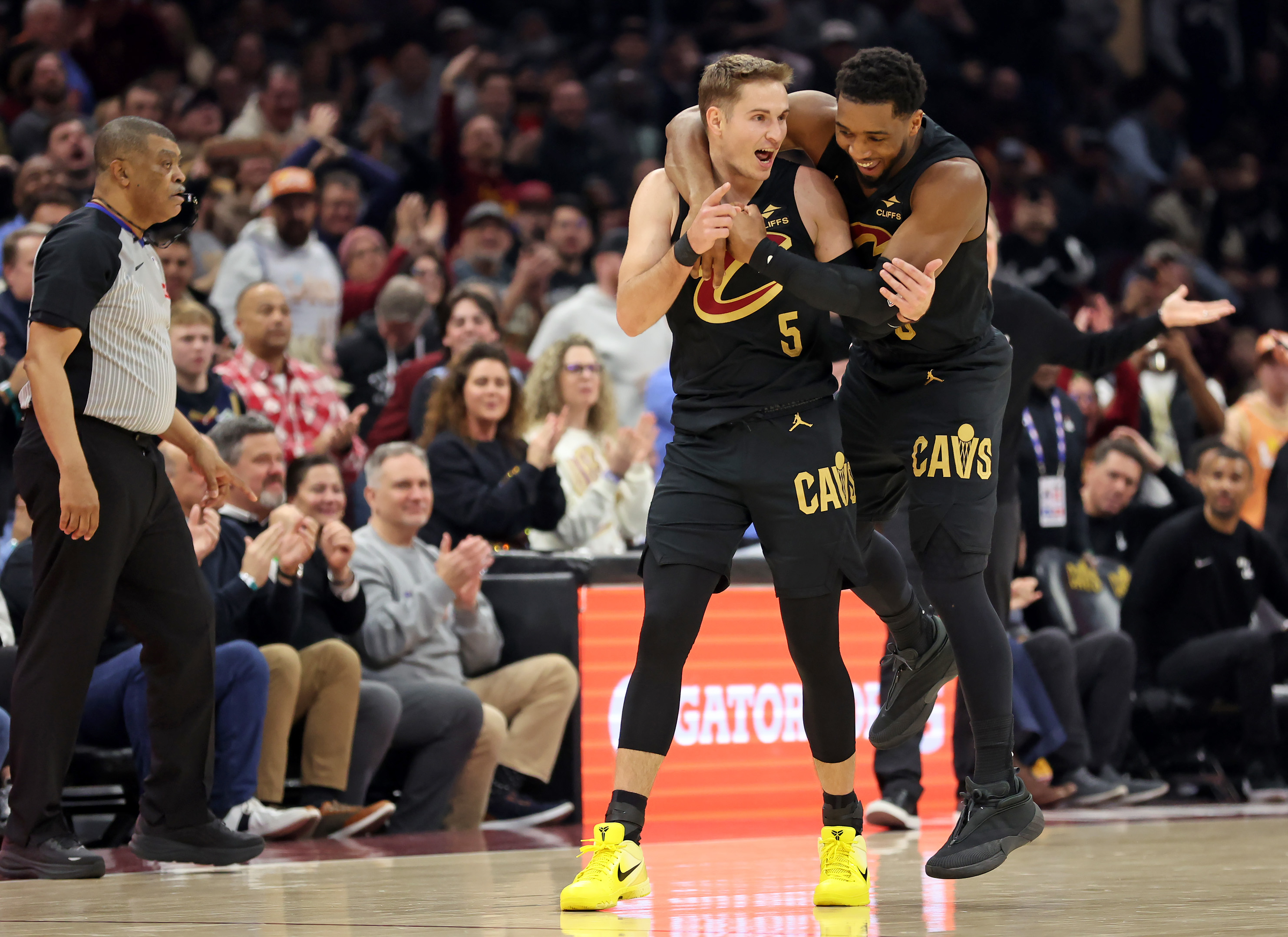 Cleveland Cavaliers guard Donovan Mitchell jumps on the back of Cleveland Cavaliers guard Sam Merrill after Merrill sank a three against the Washington Wizards in the first half of play. 