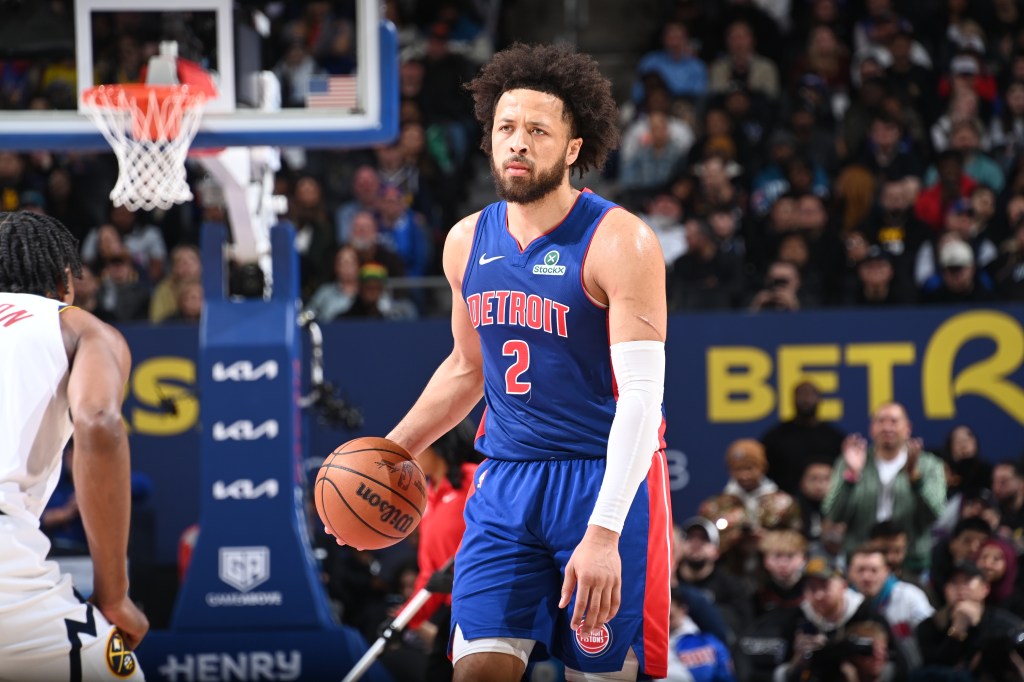 Detroit Pistons player Cade Cunningham holds a basketball during a game against the Denver Nuggets.