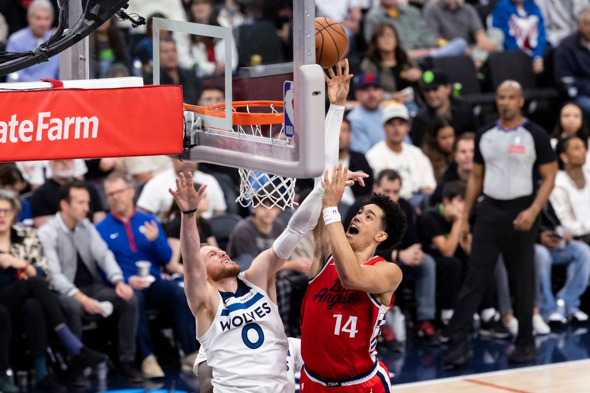 Yanic Konan Niederhauser #14 of the LA Clippers lays the ball up over Donte DiVincenzo #0 of the Minnesota Timberwolves during an NBA basketball game, Thursday February 26, 2026 in Inglewood, Calif.