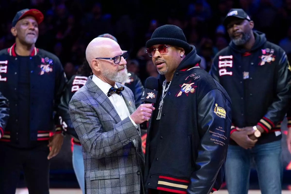 Allen Iverson, right, is interviewed by former team announcer Marc Zumoff, left, as Philadelphia 76ers honor the 2000-01 76ers team at halftime of an NBA basketball game against the New Orleans Pelicans, Saturday, Jan. 31, 2026, in Philadelphia. (AP Photo/Chris Szagola)