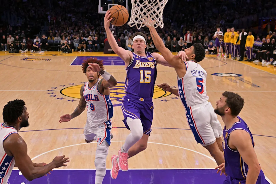 Feb 5, 2026; Los Angeles, California, USA; Los Angeles Lakers guard Austin Reaves (15) drives past Philadelphia 76ers guard Kelly Oubre Jr. (9) and guard Quentin Grimes (5) in the second half at Crypto.com Arena. Mandatory Credit: Jayne Kamin-Oncea-Imagn Images