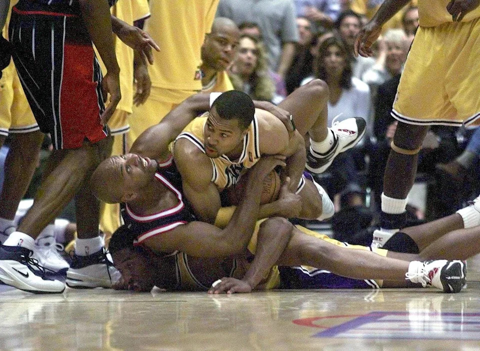 LOS ANGELES, UNITED STATES: Houston Rockets player Sam Mack(C) gets trapped between Los Angeles Lakers players Derek Fisher(top) and Kobe Bryant(bottom) during game two of the Western Conference playoff series at the Great Western Forum in Los Angeles 11 May 1999. The Lakers defeated the Rockets 110-98 to lead the best-of-five series 2-0. (ELECTRONIC IMAGE) AFP PHOTO VINCE BUCCI (Photo credit should read Vince Bucci/AFP via Getty Images)