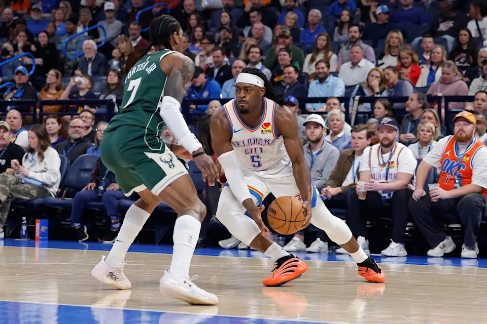 Feb 12, 2026; Oklahoma City, Oklahoma, USA; Oklahoma City Thunder guard Luguentz Dort (5) moves the ball against Milwaukee Bucks guard/forward Kevin Porter Jr. (7) during the second half at Paycom Center. Mandatory Credit: Alonzo Adams-Imagn Images