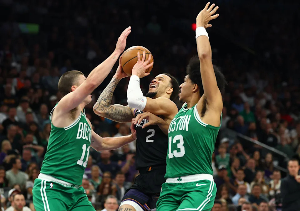 Feb 24, 2026; Phoenix, Arizona, USA; Phoenix Suns guard Amir Coffey (2) drives to the basket against Boston Celtics guard Ron Harper Jr. (13) and Payton Pritchard (11) in the first half at Mortgage Matchup Center. Mandatory Credit: Mark J. Rebilas-Imagn Images