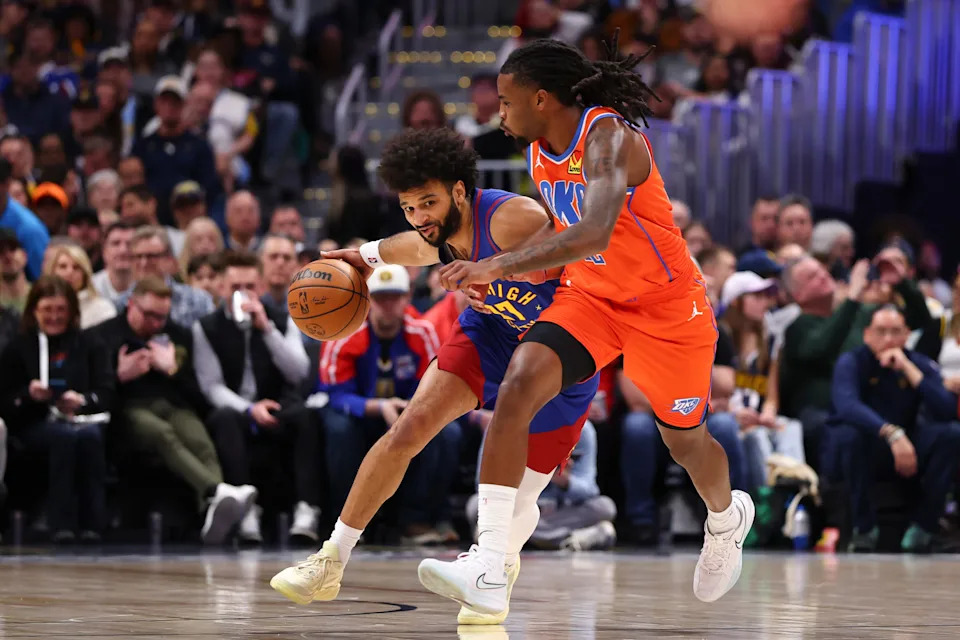 DENVER, COLORADO - FEBRUARY 01: Jamal Murray #27 of the Denver Nuggets is defended by Cason Wallace #22 of the Oklahoma City Thunder during the first quarter at Ball Arena on February 1, 2026 in Denver, Colorado. NOTE TO USER: User expressly acknowledges and agrees that, by downloading and or using this photograph, User is consenting to the terms and conditions of the Getty Images License Agreement. (Photo by Justin Tafoya/Getty Images)