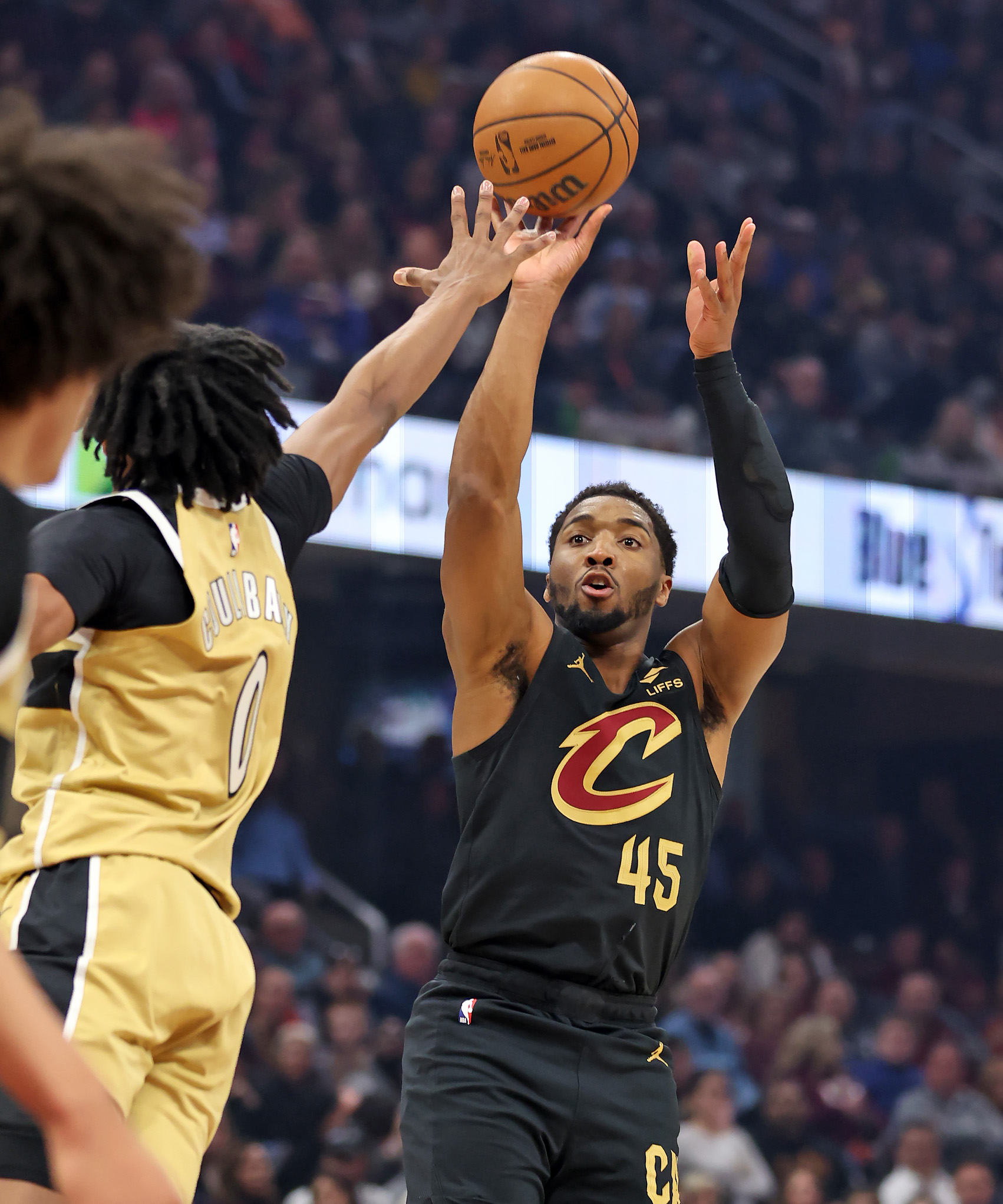 Cleveland Cavaliers guard Donovan Mitchell shoots a three over Washington Wizards guard Bilal Coulibaly in the first half of play. 