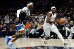 Portland Trail Blazers guard Jrue Holiday, right, works around Minnesota Timberwolves forward Jaden McDaniels during the first half of an NBA basketball game, Wednesday, Feb. 11, 2026, in Minneapolis.