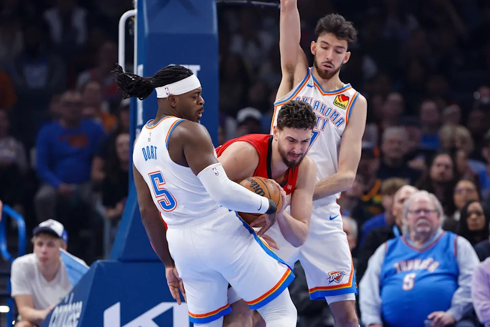 Feb 7, 2026; Oklahoma City, Oklahoma, USA; Houston Rockets center Alperen Sengun (28) fights for control of the ball with Oklahoma City Thunder guard Luguentz Dort (5) and center/forward Chet Holmgren (7) during the first half at Paycom Center. Mandatory Credit: Alonzo Adams-Imagn Images