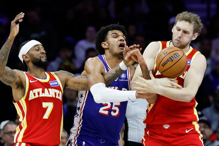 Sixers forward Dominick Barlow (center) goes and Atlanta Hawks center Jock Landale (right) battle for the basketball during the third quarter on Thursday night.