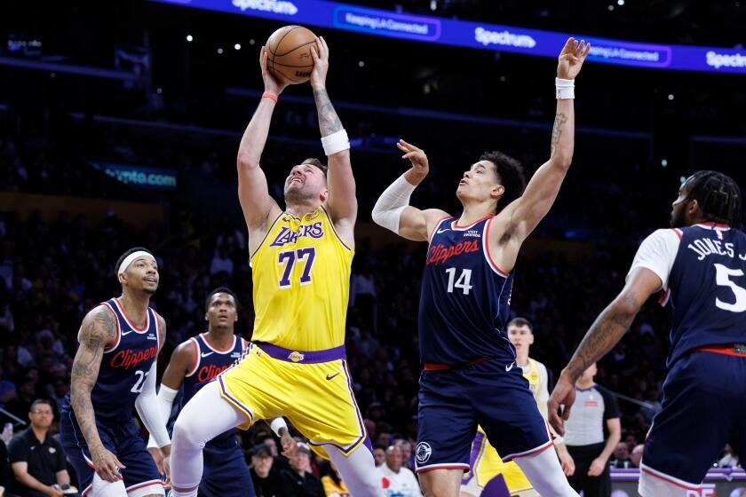 Lakers guard Luka Doncic scores in front of Clippers center Yanic Konan Niederhauser at Crypto.com Arena on Friday.