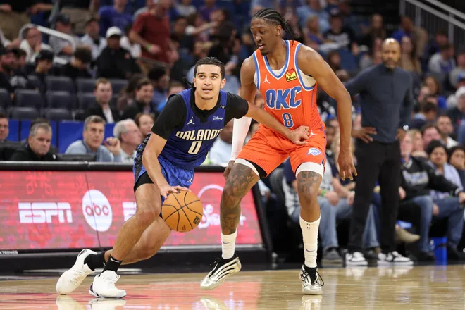 Dec 19, 2024; Orlando, Florida, USA; Orlando Magic guard Anthony Black (0) is guarded by Oklahoma City Thunder forward Jalen Williams (8) in the fourth quarter at Kia Center. Mandatory Credit: Nathan Ray Seebeck-Imagn Images