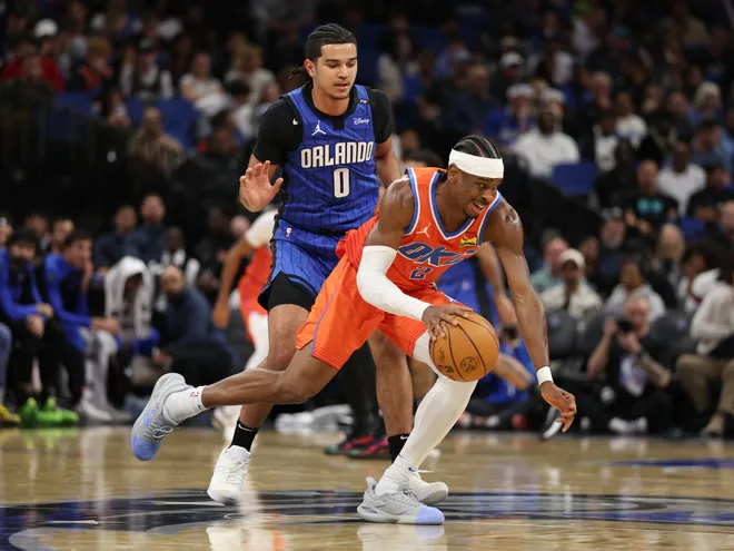 Dec 19, 2024; Orlando, Florida, USA; Oklahoma City Thunder guard Shai Gilgeous-Alexander (2) controls the ball from Orlando Magic guard Anthony Black (0) in the first quarter at Kia Center. Mandatory Credit: Nathan Ray Seebeck-Imagn Images