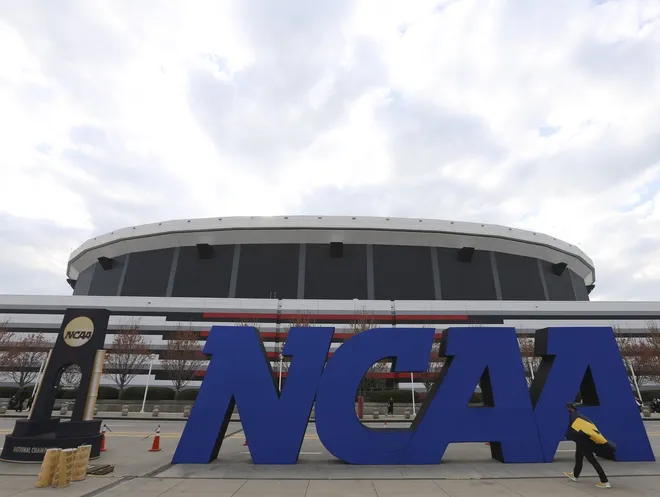 Apr 8, 2013; Atlanta, GA, USA; Fans take photos in front of a giant NCAA logo and championship trophy before the championship game in the 2013 NCAA mens Final Four at the Georgia Dome.