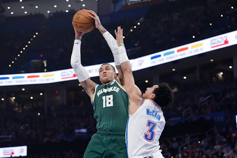 Feb 12, 2026; Oklahoma City, Oklahoma, USA; Milwaukee Bucks forward Kyle Kuzma (18) grabs a rebound away from Oklahoma City Thunder guard Jared McCain (3) during the first half at Paycom Center. Mandatory Credit: Alonzo Adams-Imagn Images
