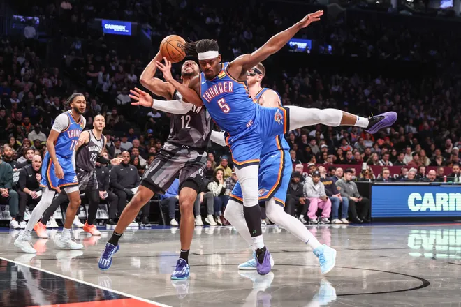 Feb 26, 2025; Brooklyn, New York, USA; Brooklyn Nets forward Tosan Evbuomwan (12) looks to post up against Oklahoma City Thunder guard Luguentz Dort (5) in the third quarter at Barclays Center. Mandatory Credit: Wendell Cruz-Imagn Images