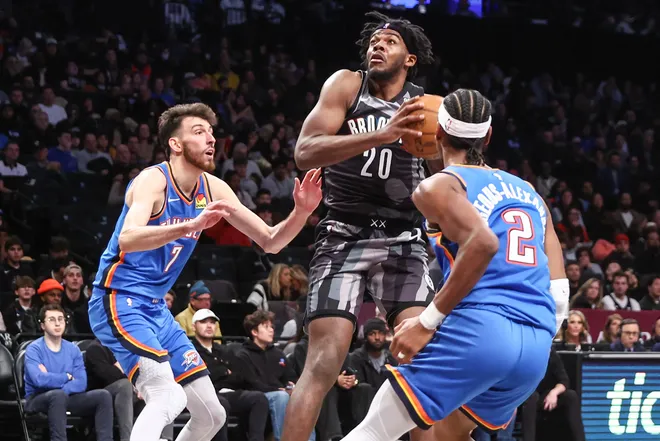 Feb 26, 2025; Brooklyn, New York, USA; Brooklyn Nets center Day'Ron Sharpe (20) looks to drive past Oklahoma City Thunder forward Chet Holmgren (7) and guard Shai Gilgeous-Alexander (2) in the third quarter at Barclays Center. Mandatory Credit: Wendell Cruz-Imagn Images