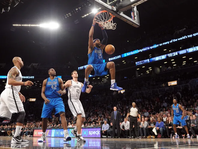 Vince Carter (R) of the Dallas Mavericks dunks against Kris Humphries (2R) of the Brooklyn Nets as Elton Brand (2L) of the Mavericks watches at the Barclays Center March 1, 2013 in the Brooklyn borough of New York. AFP PHOTO/Stan HONDA