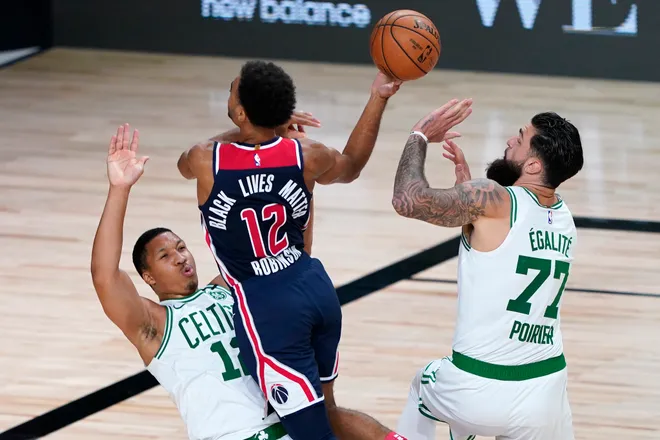 Aug 13, 2020; Lake Buena Vista, Florida, USA; Washington Wizards' Jerome Robinson, center, heads to the basket as Boston Celtics' Grant Williams, left, and Vincent Poirier (77) defend during the second half of an NBA basketball game Thursday, Aug. 13, 2020 in Lake Buena Vista, Fla. at ESPN Wide World of Sports Complex. Mandatory Credit: Ashley Landis/Pool Photo-USA TODAY Sports