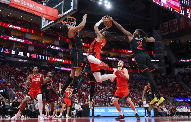 Feb 9, 2025; Houston, Texas, USA; Houston Rockets forward Cam Whitmore (7) shoots the ball as Toronto Raptors forward Scottie Barnes (4) and forward Jonathan Mogbo (2) defend during the fourth quarter at Toyota Center. Mandatory Credit: Troy Taormina-Imagn Images