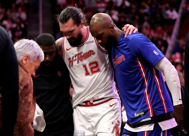 Jan 18, 2026; Houston, Texas, USA; Houston Rockets center Steven Adams (12) is helped off the court after an injury against the New Orleans Pelicans during the fourth quarter at Toyota Center. Mandatory Credit: Erik Williams-Imagn Images
