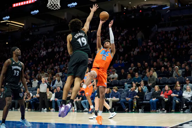 Jan 29, 2026; Minneapolis, Minnesota, USA; Oklahoma City Thunder forward Ousmane Dieng (13) shoots through the defense of Minnesota Timberwolves forward Joan Beringer (19) in the fourth quarter at Target Center. Mandatory Credit: Matt Blewett-Imagn Images