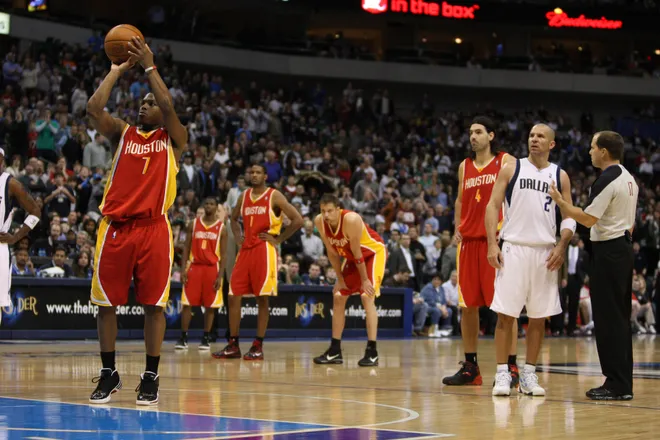Dec 18, 2009; Dallas, TX, USA; Houston Rockets guard Kyle Lowry (7) shoots a technical foul shot as Dallas Mavericks guard Jason Kidd (2) talks to a referee at American Airlines Arena. The Rockets beat the Mavs in overtime 116-108. Mandatory Credit: Photo By Matthew Emmons-USA TODAY Sports