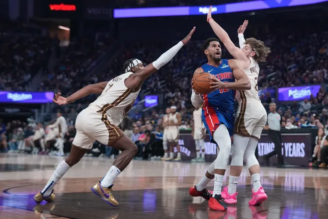 Jan 30, 2026; San Francisco, California, USA; Detroit Pistons forward Tobias Harris (12) drives against Golden State Warriors guard Buddy Hield (7) and guard Brandin Podziemski (2) in the second quarter at the Chase Center.