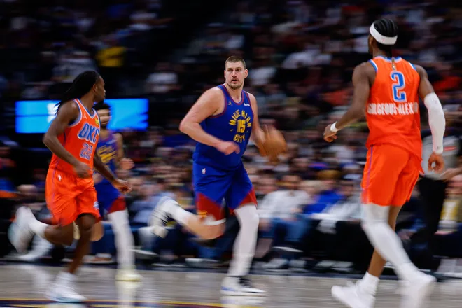 Feb 1, 2026; Denver, Colorado, USA; Denver Nuggets center Nikola Jokic (15) dribbles the ball up court against Oklahoma City Thunder guard Cason Wallace (22) and guard Shai Gilgeous-Alexander (2) in the fourth quarter at Ball Arena. Mandatory Credit: Isaiah J. Downing-Imagn Images