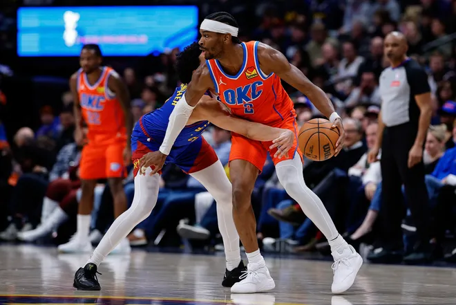 Feb 1, 2026; Denver, Colorado, USA; Oklahoma City Thunder guard Shai Gilgeous-Alexander (2) controls the ball under pressure from Denver Nuggets guard Julian Strawther (3) in the fourth quarter at Ball Arena. Mandatory Credit: Isaiah J. Downing-Imagn Images