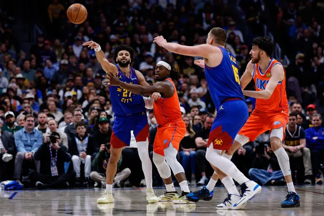 Feb 1, 2026; Denver, Colorado, USA; Denver Nuggets guard Jamal Murray (27) passes the ball to center Nikola Jokic (15) under pressure from Oklahoma City Thunder guard Luguentz Dort (5) as center Chet Holmgren (7) defends in the second quarter at Ball Arena. Mandatory Credit: Isaiah J. Downing-Imagn Images