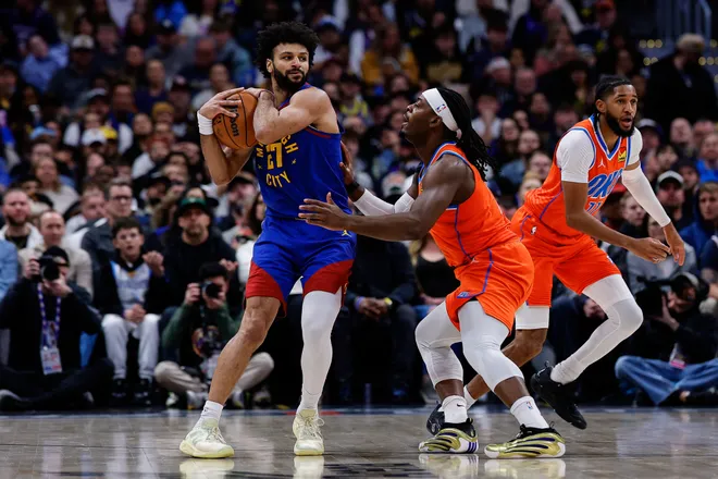 Feb 1, 2026; Denver, Colorado, USA; Denver Nuggets guard Jamal Murray (27) controls the ball as Oklahoma City Thunder guard Luguentz Dort (5) guards in the second quarter at Ball Arena. Mandatory Credit: Isaiah J. Downing-Imagn Images