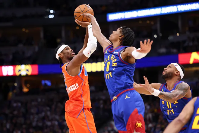 DENVER, COLORADO - FEBRUARY 01: Shai Gilgeous-Alexander #2 of the Oklahoma City Thunder shoots the ball over Peyton Watson #8 of the Denver Nuggets during the fourth quarter at Ball Arena on February 1, 2026 in Denver, Colorado. NOTE TO USER: User expressly acknowledges and agrees that, by downloading and or using this photograph, User is consenting to the terms and conditions of the Getty Images License Agreement. (Photo by Justin Tafoya/Getty Images)