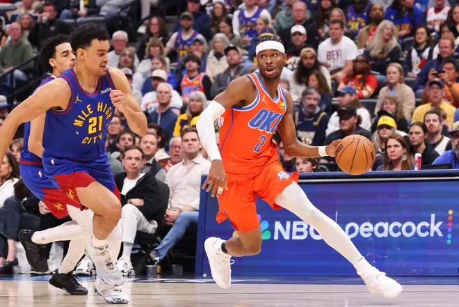 DENVER, COLORADO - FEBRUARY 01: Shai Gilgeous-Alexander #2 of the Oklahoma City Thunder drives to the basket against Spencer Jones #21 of the Denver Nuggets during the fourth quarter at Ball Arena on February 1, 2026 in Denver, Colorado. NOTE TO USER: User expressly acknowledges and agrees that, by downloading and or using this photograph, User is consenting to the terms and conditions of the Getty Images License Agreement. (Photo by Justin Tafoya/Getty Images)