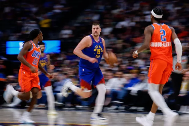 Feb 1, 2026; Denver, Colorado, USA; Denver Nuggets center Nikola Jokic (15) dribbles the ball up court against Oklahoma City Thunder guard Cason Wallace (22) and guard Shai Gilgeous-Alexander (2) in the fourth quarter at Ball Arena.