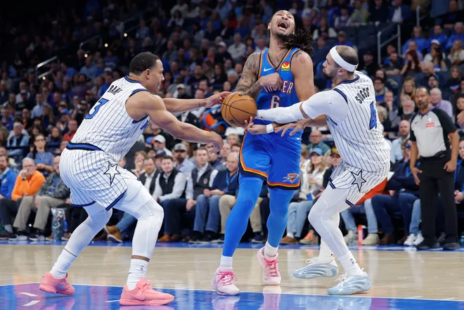 Feb 3, 2026; Oklahoma City, Oklahoma, USA; Oklahoma City Thunder forward Jaylin Williams (6) has the ball stopped away during a drip to the basket between Orlando Magic guard Jett Howard (13) and Orlando Magic guard Jalen Suggs (4) during the second half at Paycom Center. Mandatory Credit: Alonzo Adams-Imagn Images