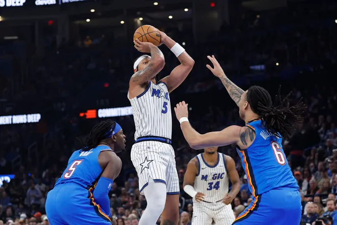 Feb 3, 2026; Oklahoma City, Oklahoma, USA; Orlando Magic forward Paolo Banchero (5) shoots from between Oklahoma City Thunder guard Luguentz Dort (5) and forward Jaylin Williams (6) during the second quarter at Paycom Center. Mandatory Credit: Alonzo Adams-Imagn Images