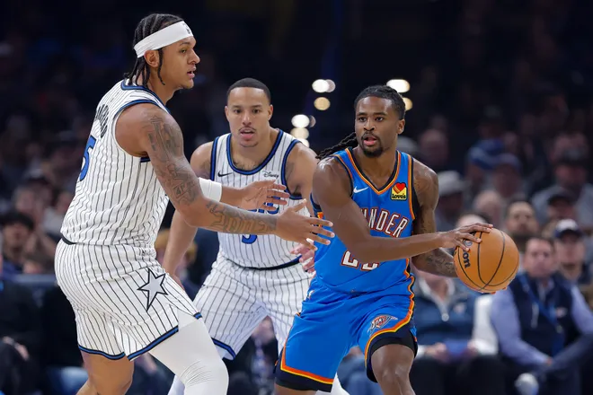 Feb 3, 2026; Oklahoma City, Oklahoma, USA; Oklahoma City Thunder guard Cason Wallace (22) moves the ball around Orlando Magic forward Paolo Banchero (5) during the first quarter at Paycom Center. Mandatory Credit: Alonzo Adams-Imagn Images