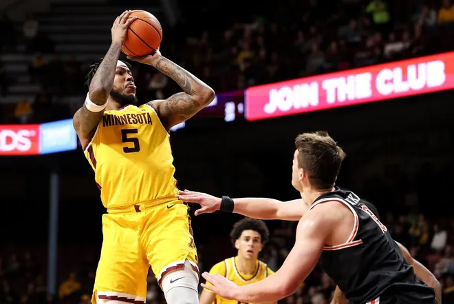 Dec 21, 2025; Minneapolis, Minnesota, USA; Minnesota Golden Gophers forward Jaylen Crocker-Johnson (5) shoots as Campbell Fighting Camels forward Dovydas Butka (13) defends during the first half at Williams Arena.