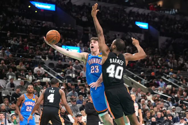 Feb 4, 2026; San Antonio, Texas, USA; Oklahoma City Thunder guard Brooks Barnhizer (23) drives to the basket against San Antonio Spurs forward Harrison Barnes (40) during the second half at Frost Bank Center. Mandatory Credit: Scott Wachter-Imagn Images