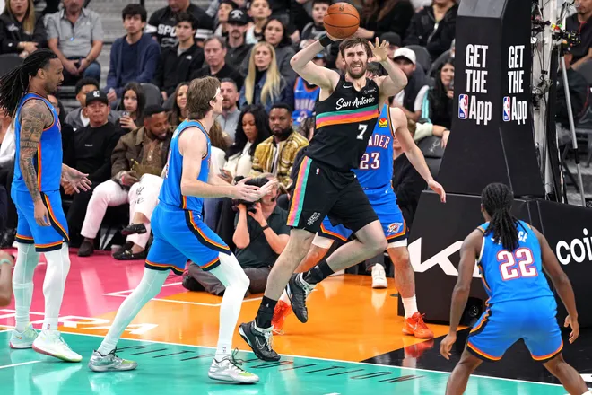 Feb 4, 2026; San Antonio, Texas, USA; San Antonio Spurs center Luke Kornet (7) saves the ball from going out of bounds ahead of Oklahoma City Thunder center Branden Carlson (15) and forward Jaylin Williams (6) during the second half at Frost Bank Center. Mandatory Credit: Scott Wachter-Imagn Images