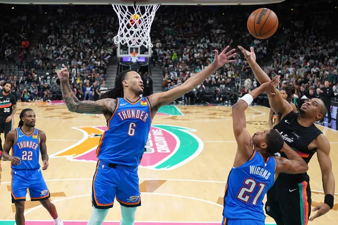 Feb 4, 2026; San Antonio, Texas, USA; Oklahoma City Thunder forward Jaylin Williams (6) and guard Aaron Wiggins (21) reach for a rebound along with San Antonio Spurs forward Keldon Johnson (3) during the second half at Frost Bank Center. Mandatory Credit: Scott Wachter-Imagn Images