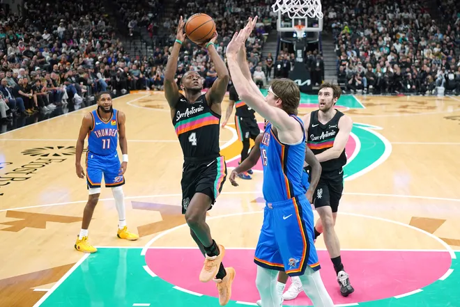 Feb 4, 2026; San Antonio, Texas, USA; San Antonio Spurs guard De’Aaron Fox (4) drives to the basket against center Branden Carlson (15) during the second half at Frost Bank Center. Mandatory Credit: Scott Wachter-Imagn Images