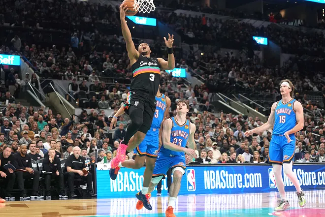 Feb 4, 2026; San Antonio, Texas, USA; San Antonio Spurs forward Keldon Johnson (3) drives to the basket past Oklahoma City Thunder guard Brooks Barnhizer (23) during the first half at Frost Bank Center. Mandatory Credit: Scott Wachter-Imagn Images
