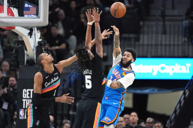 Feb 4, 2026; San Antonio, Texas, USA; Oklahoma City Thunder forward Kenrich Williams (34) passes the ball over San Antonio Spurs forward Victor Wembanyama (1) and guard Stephon Castle (5) during the first half at Frost Bank Center. Mandatory Credit: Scott Wachter-Imagn Images