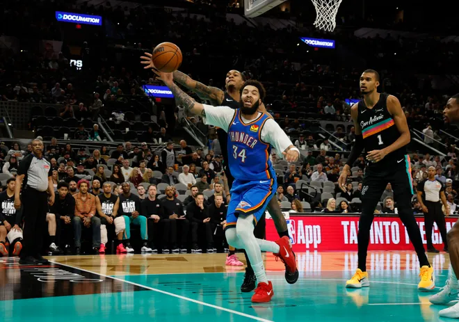 SAN ANTONIO, TX - FEBRUARY 4: Devin Vassell #24 of the San Antonio Spurs reaches over Kenrich Williams #34 of the Oklahoma City Thunder for a loose ball in the second half at Frost Bank Center on February 1, 2026 in San Antonio, Texas. NOTE TO USER: User expressly acknowledges and agrees that, by downloading and or using this photograph, User is consenting to terms and conditions of the Getty Images License Agreement. (Photo by Ronald Cortes/Getty Images)