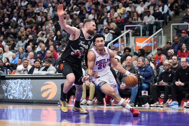 Jan 12, 2026; Toronto, Ontario, CAN; Philadelphia 76ers guard Jared McCain (20) drives to the net past Toronto Raptors forward Sandro Mamukelashvili (54) during the first half at Scotiabank Arena. Mandatory Credit: John E. Sokolowski-Imagn Images