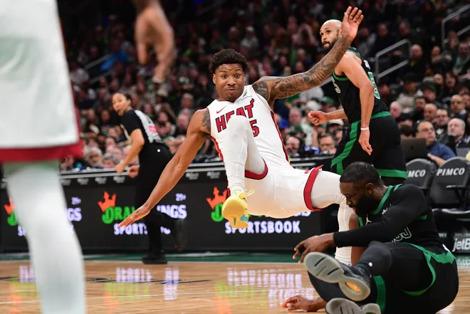 Feb 6, 2026; Boston, Massachusetts, USA; Miami Heat guard Davion Mitchell (45) falls over Boston Celtics guard Jaylen Brown (7) during the second half at TD Garden. Mandatory Credit: Bob DeChiara-Imagn Images