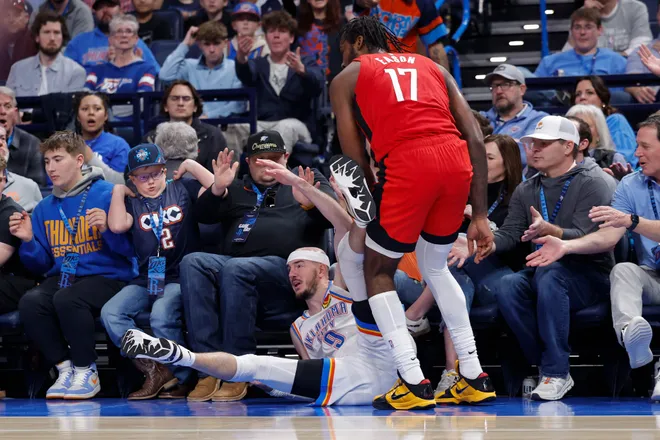 Feb 7, 2026; Oklahoma City, Oklahoma, USA; Oklahoma City Thunder guard Alex Caruso (9) and Houston Rockets forward Tari Eason (17) fall into fans during the second half at Paycom Center. Mandatory Credit: Alonzo Adams-Imagn Images