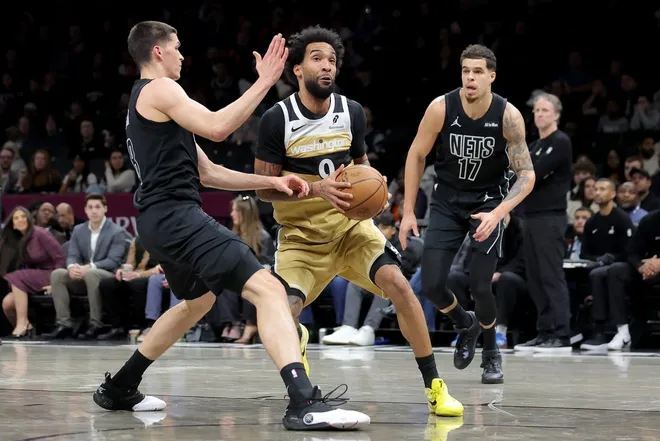 Feb 7, 2026; Brooklyn, New York, USA; Washington Wizards forward Justin Champagnie (9) drives to the basket against Brooklyn Nets guard Egor Demin (8) and forward Michael Porter Jr. (17) during the first quarter at Barclays Center.