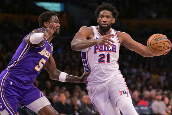 Feb 5, 2026; Los Angeles, California, USA; Philadelphia 76ers center Joel Embiid (21) is defended by Los Angeles Lakers center Deandre Ayton (5) in the first half at Crypto.com Arena. Mandatory Credit: Jayne Kamin-Oncea-Imagn Images